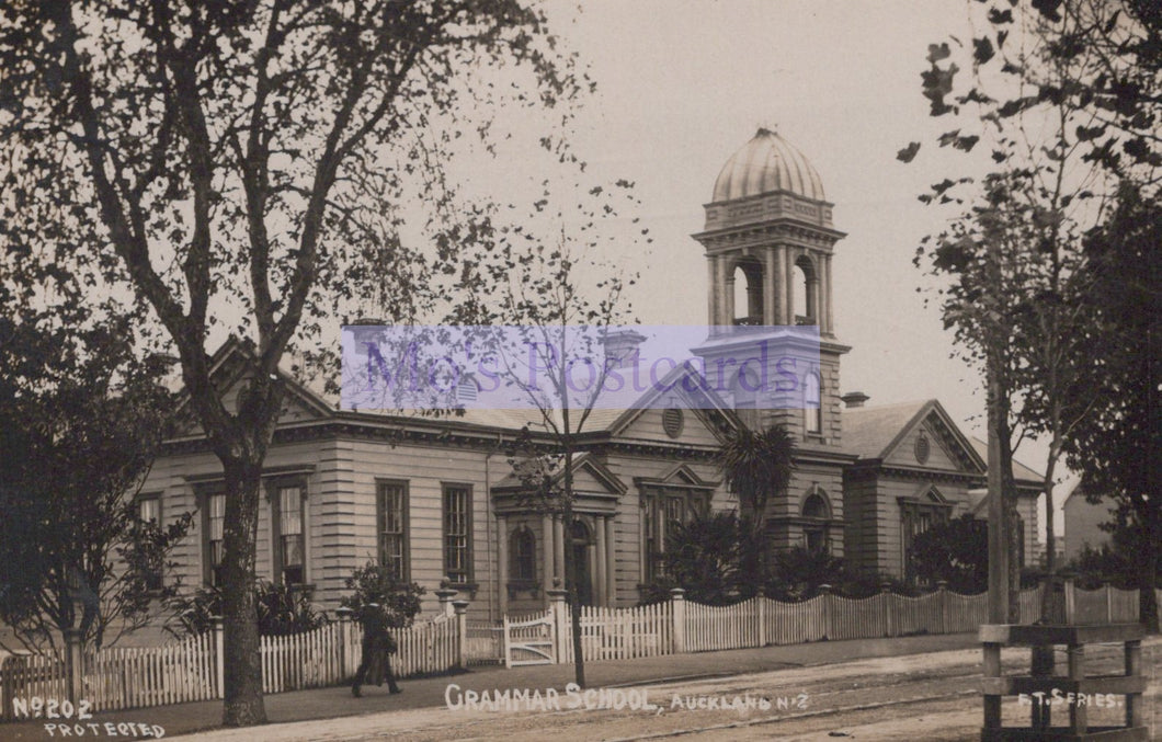 Vintage photograph of a school building with a clock tower, surrounded by trees.