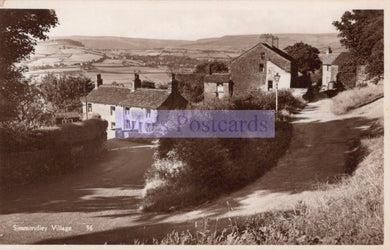 Vintage black and white photo of a village with houses and a road.