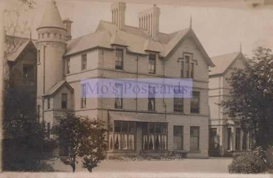 Vintage photograph of a large, ornate house with a prominent tower.