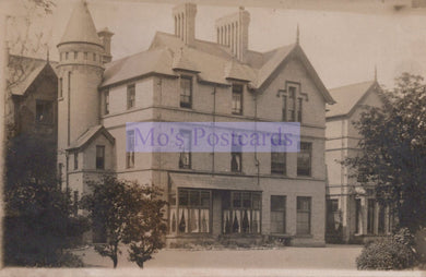 Vintage photograph of a large, ornate house with a prominent tower.