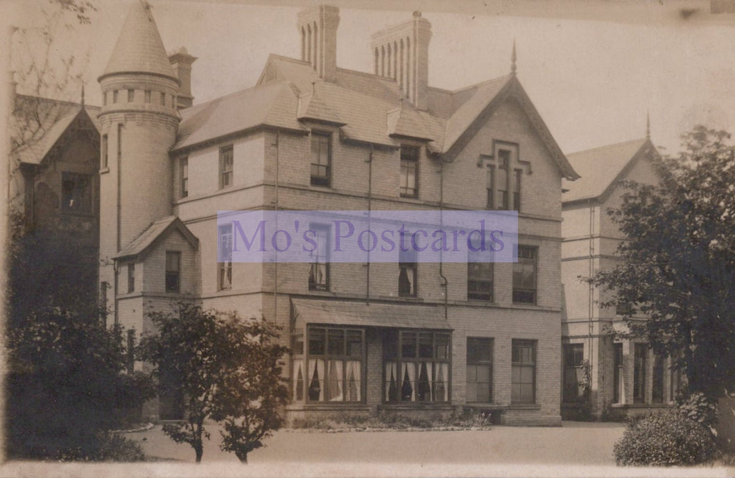 Vintage photograph of a large, ornate house with a prominent tower.