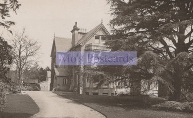 Vintage black and white photograph of a large house with a driveway and trees.