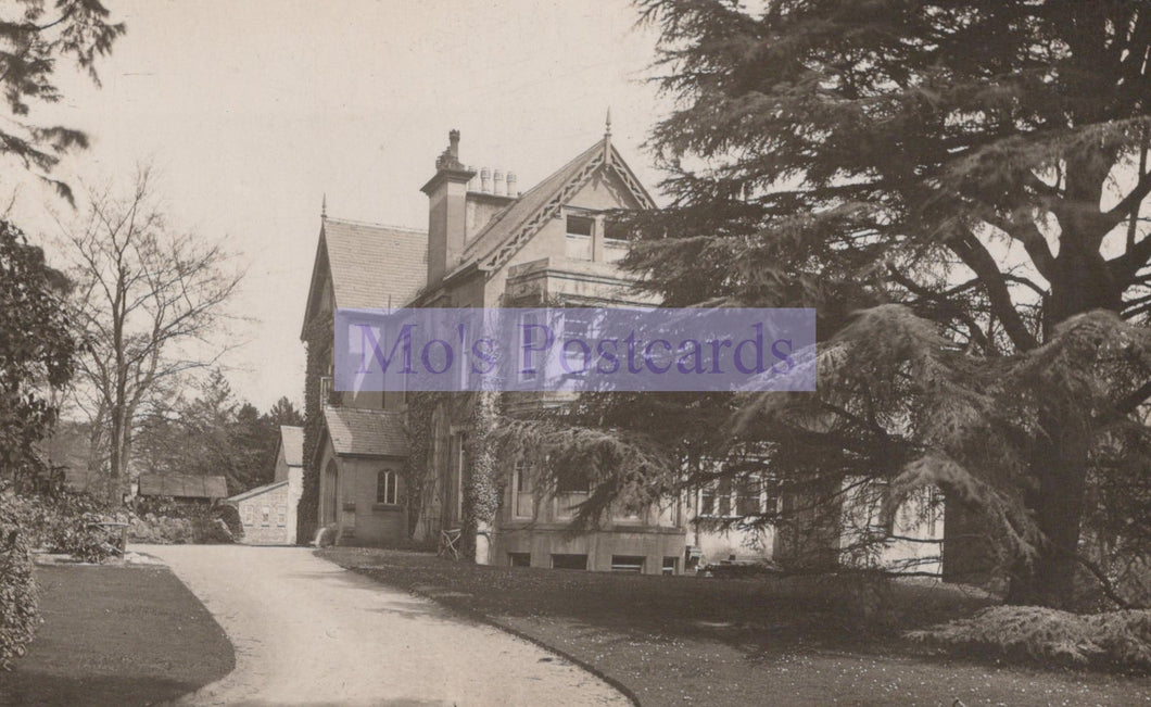 Vintage black and white photograph of a large house with a driveway and trees.