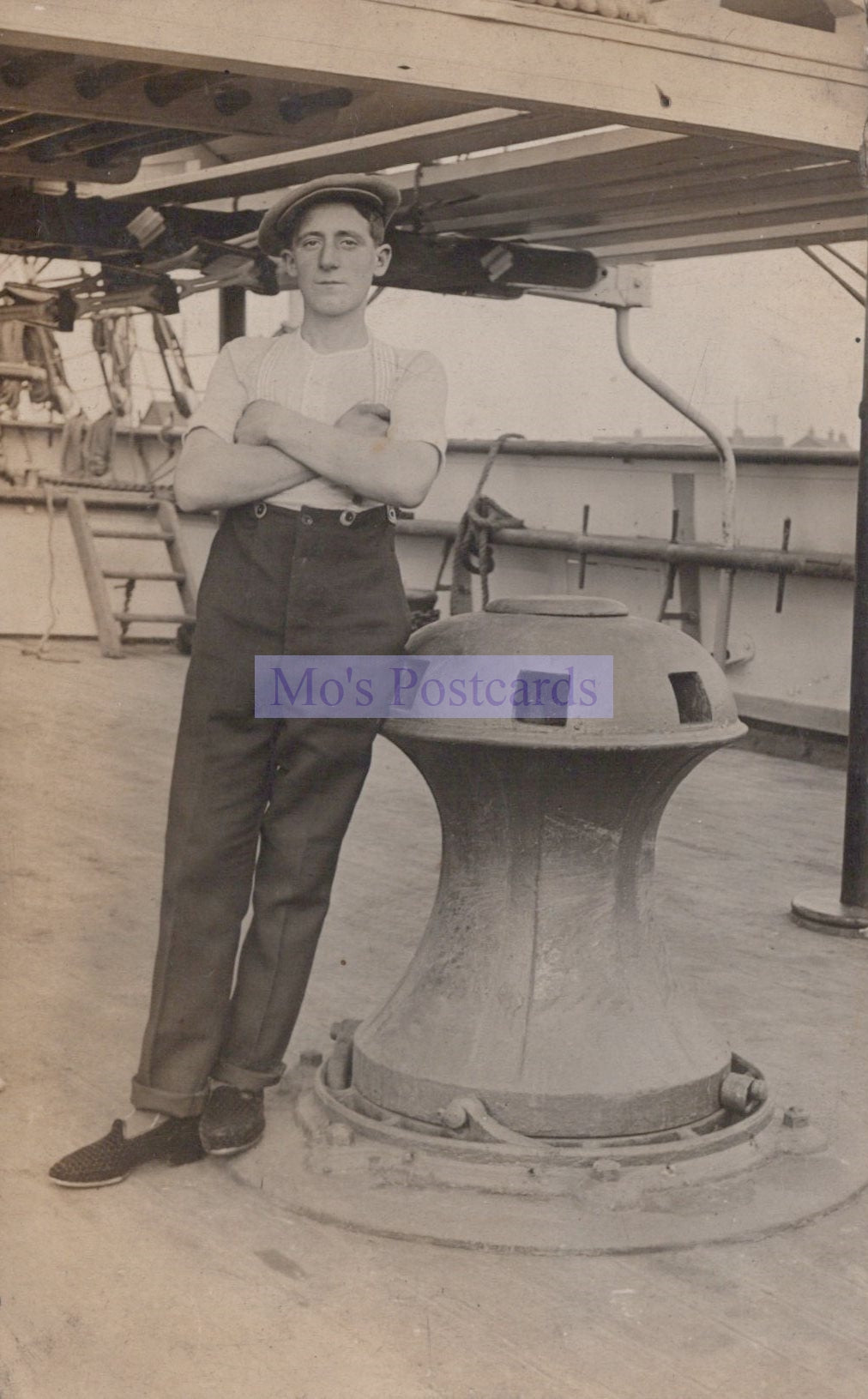 Vintage black and white photo of a man standing on a ship with a large wheel.
