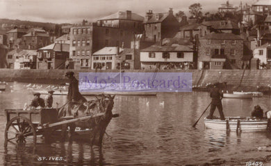 Vintage black and white photo of a harbor scene with people and a cart in the water, buildings in the background.