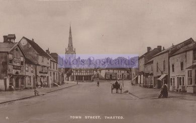 Vintage black and white photograph of a town street with buildings and a church spire.