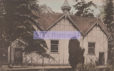 Vintage photograph of a school building with a steeple, surrounded by trees.