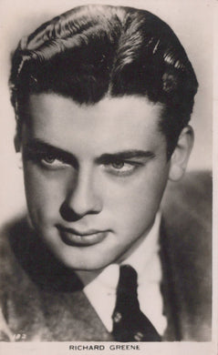 Black and white portrait of a man with styled hair, wearing a suit.