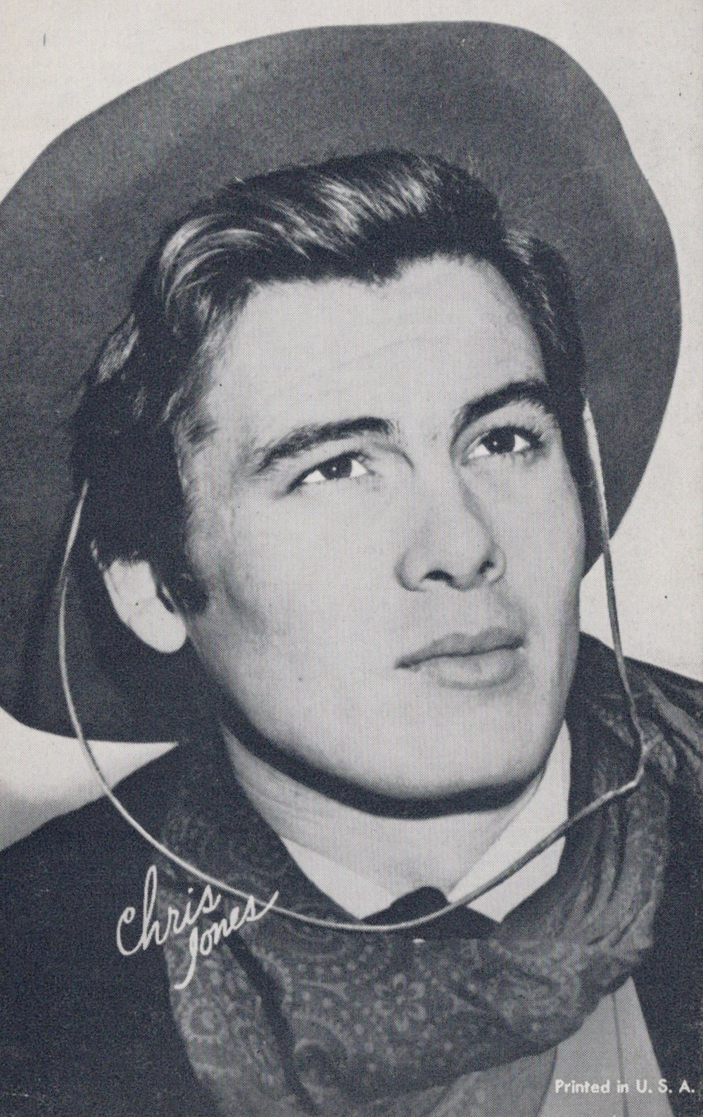 Vintage photo of a person wearing a cowboy hat and scarf with 'Chris Jones' signature.