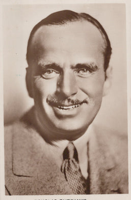 Vintage black and white portrait of a man with a mustache, wearing a suit and tie.