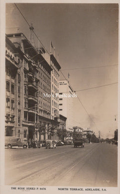 Vintage black and white photo of a city street with buildings and car 