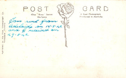 Vintage postcard with a rose illustration and handwritten text on a white background