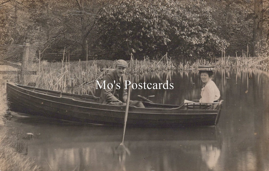 Two people in a boat on a calm body of water with 'Mo's Postcards' text overlay.