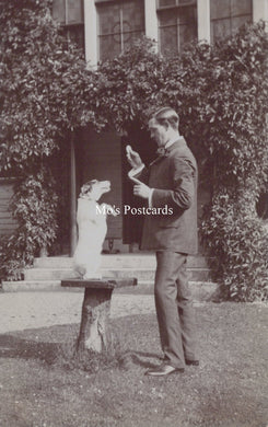Vintage black and white photo of a man and dog in a garden setting 