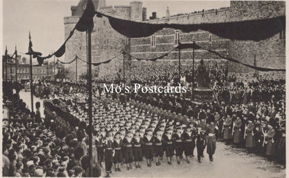 Vintage black and white photo of a formal event with people in uniform and a building in the background.