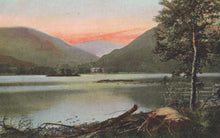 Load image into Gallery viewer, Landscape with a lake, mountains, and a cabin at sunset.

