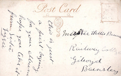 Vintage postcard with handwritten text and decorative elements on a light brown background