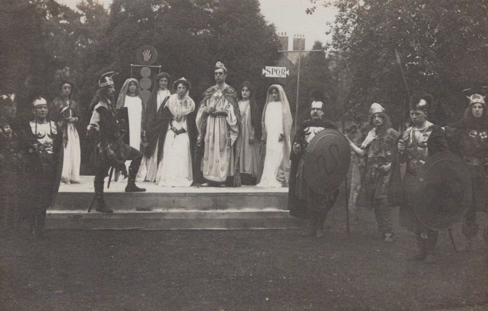 Stage performance with actors in formal attire outdoors