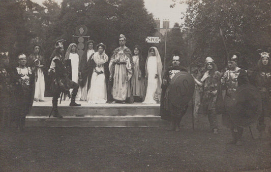 Stage performance with actors in formal attire outdoors