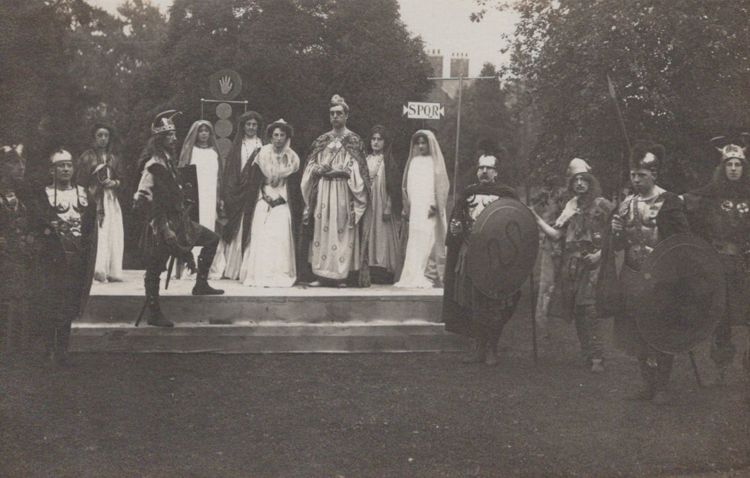 Stage performance with actors in formal attire outdoors