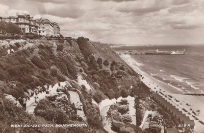 Vintage black and white photograph of a coastal scene with a zigzag path, houses, and a beach.