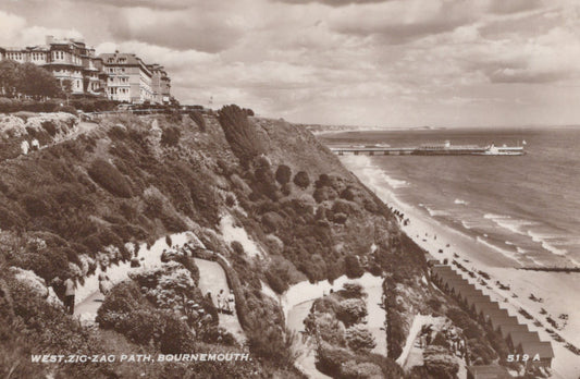 Vintage black and white photograph of a coastal scene with a zigzag path, houses, and a beach.