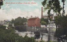 Load image into Gallery viewer, Vintage postcard of houseboats on the River Ouse in St. Neots, with a red-brick building and trees in the background.
