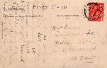 Vintage postcard with handwritten text and a red stamp on a beige background