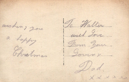 Handwritten Christmas message on a vintage card with decorative elements.