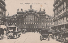 Load image into Gallery viewer, Vintage postcard of Gare du Nord in Paris with early automobiles and trams.

