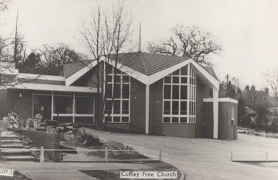 Black and white photograph of a modern church building with 'Cuffley Free Church' sign.