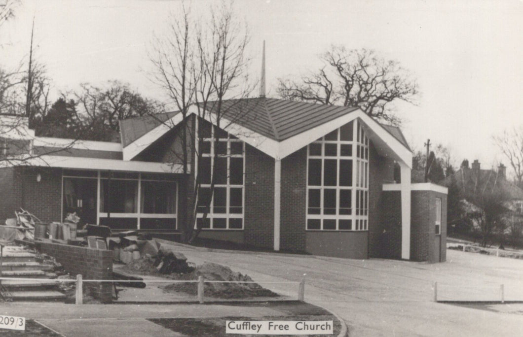 Black and white photograph of a modern church building with 'Cuffley Free Church' sign.