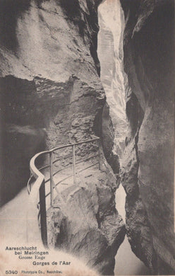 Narrow gorge with a metal staircase between two rocky walls, vintage photograph.