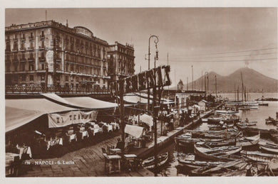 Vintage photograph of a waterfront scene with boats and buildings, featuring a large sign.