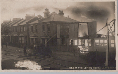 Burnt-out building with surrounding houses in a residential area, likely after a fire.