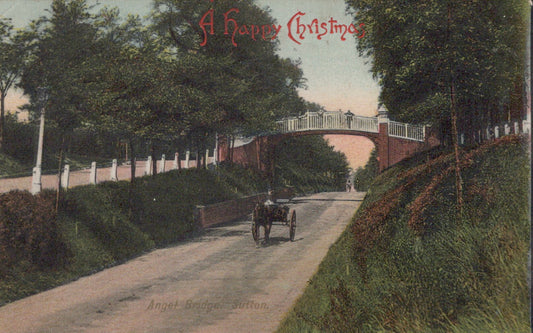 Vintage Christmas card with a car on a road, trees, and a bridge.