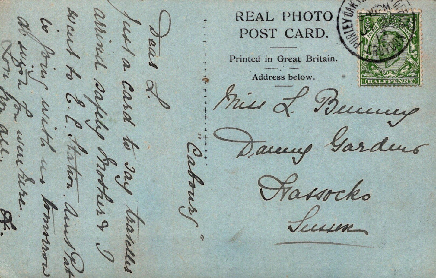 Vintage real photo postcard with text and stamp on a light blue background