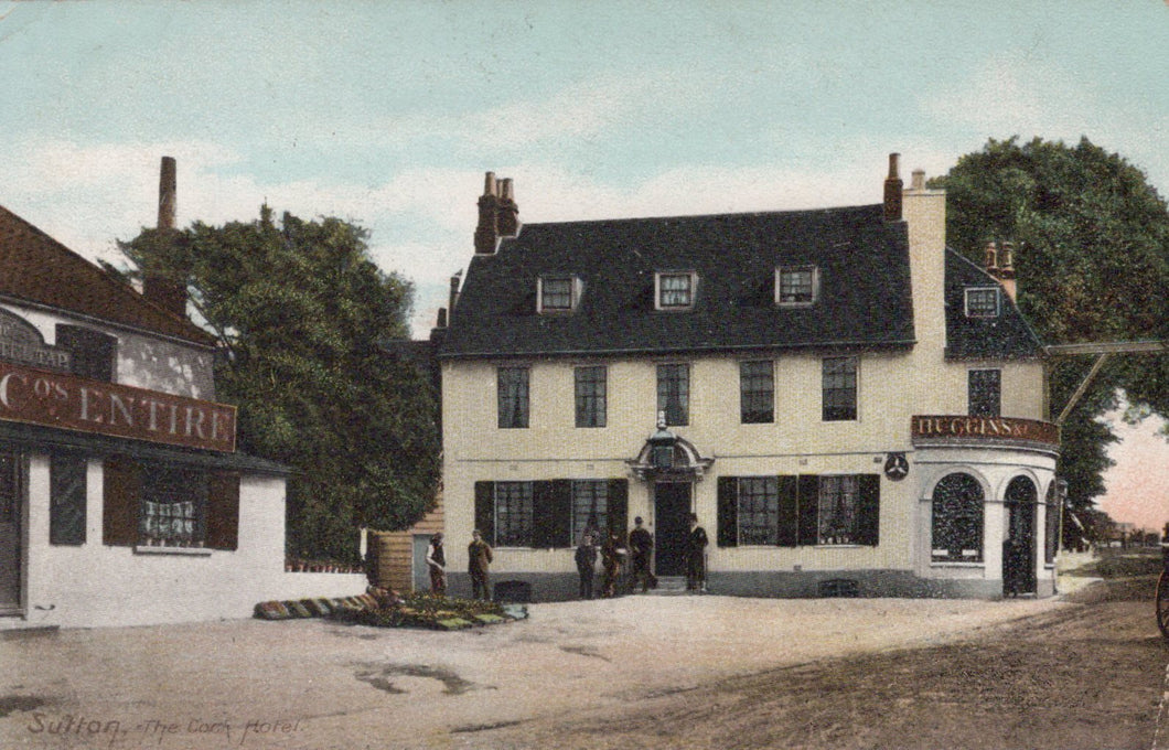Vintage postcard of a pub with people outside, surrounded by trees and other buildings.
