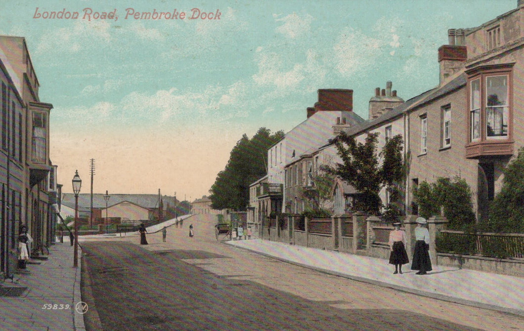 Vintage postcard of a street scene in London Road, Pembroke Dock with pedestrians and buildings.