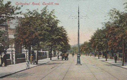 Vintage postcard of Cathedral Road, Cardiff, showing a street scene with trees, people, and a tram line.