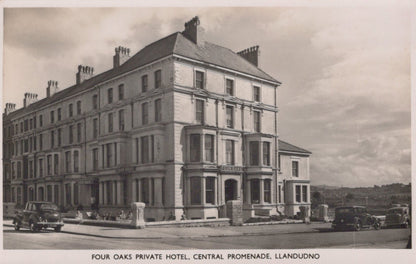 Vintage black and white photo of a large building labeled 'Four Oaks Private Hotel, Central Promenade, Llandudno'.