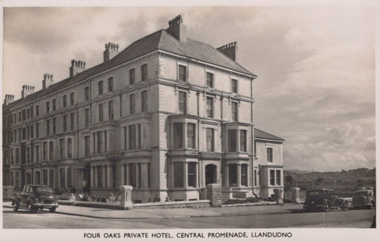 Vintage black and white photo of a large building labeled 'Four Oaks Private Hotel, Central Promenade, Llandudno'.