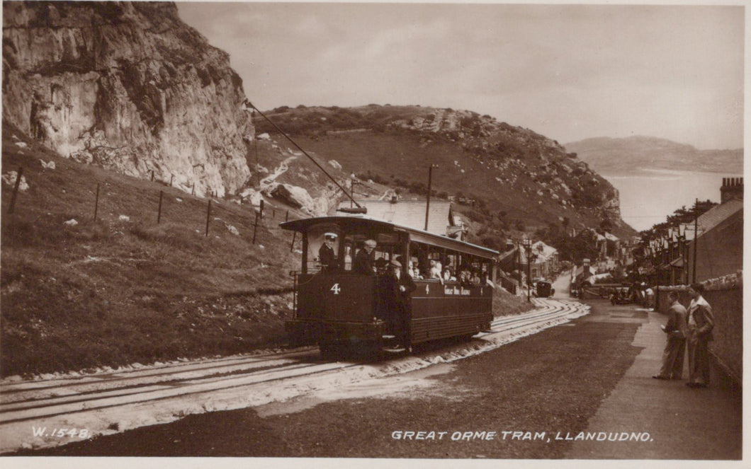 Vintage photograph of a tram on tracks with a scenic background