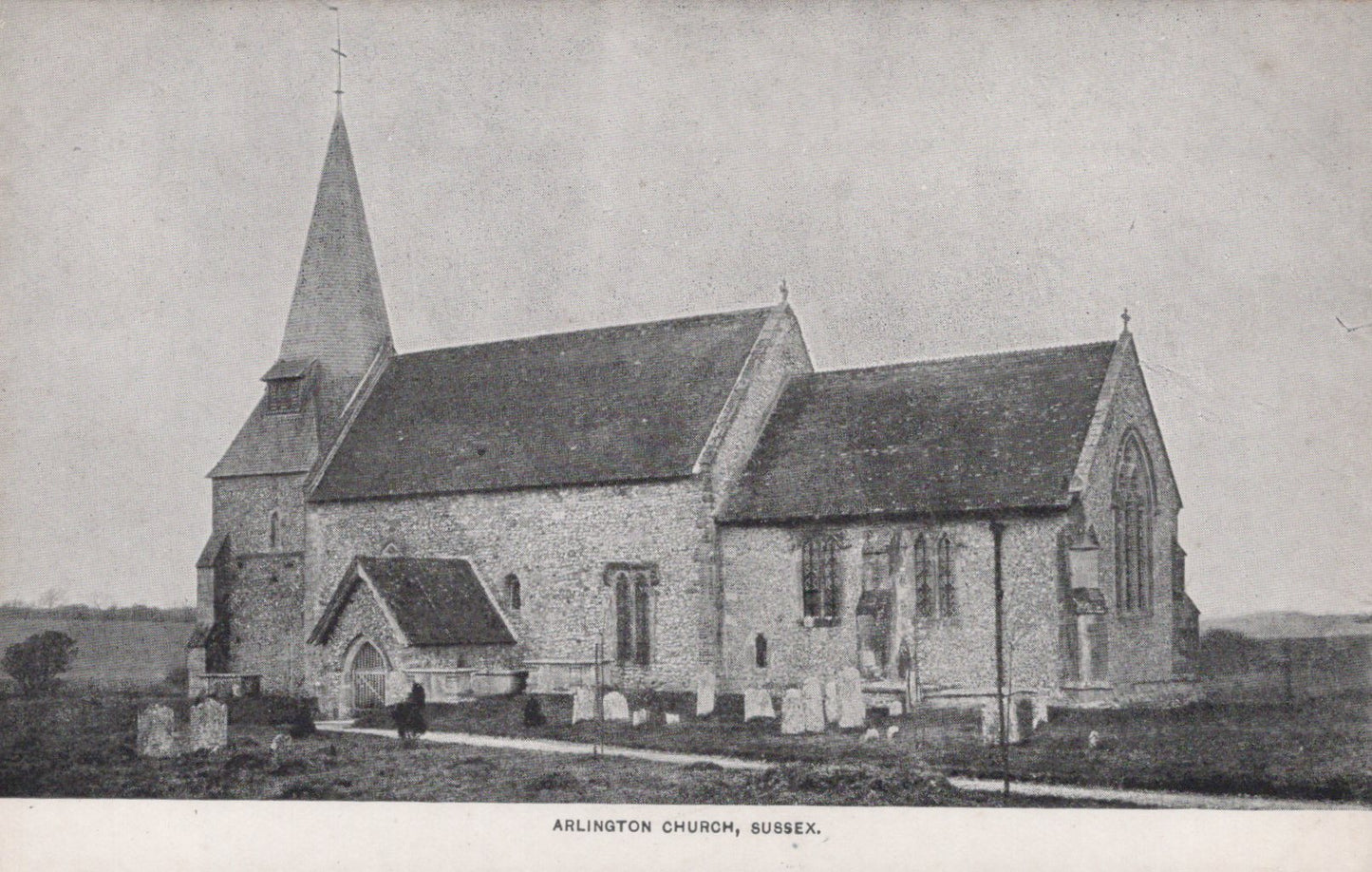 Vintage black and white photograph of a church with a steeple in a rural setting.