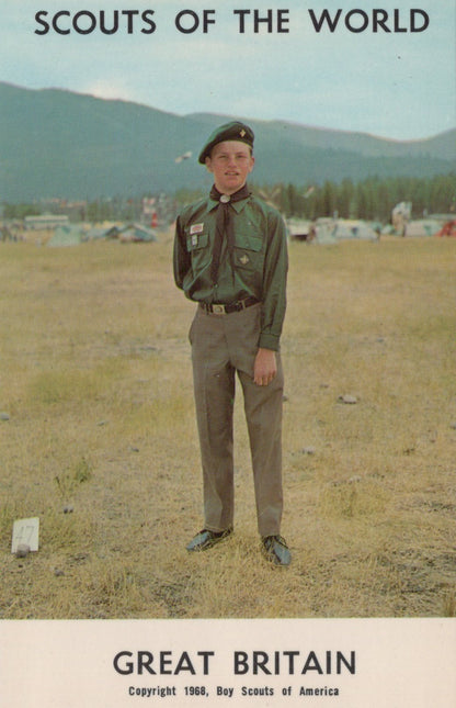 Scout in uniform standing in a field with mountains in the background, labeled 'Scouts of the World, Great Britain'.