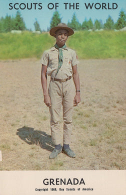 Scout in uniform standing in a field with 'Scouts of the World Grenada' text at the top.