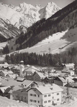Load image into Gallery viewer, Vintage black and white photograph of a mountain village with snow-capped peaks.
