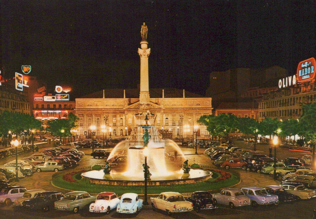 Famous landmark at night with fountain and surrounding cars, illuminated by streetlights.