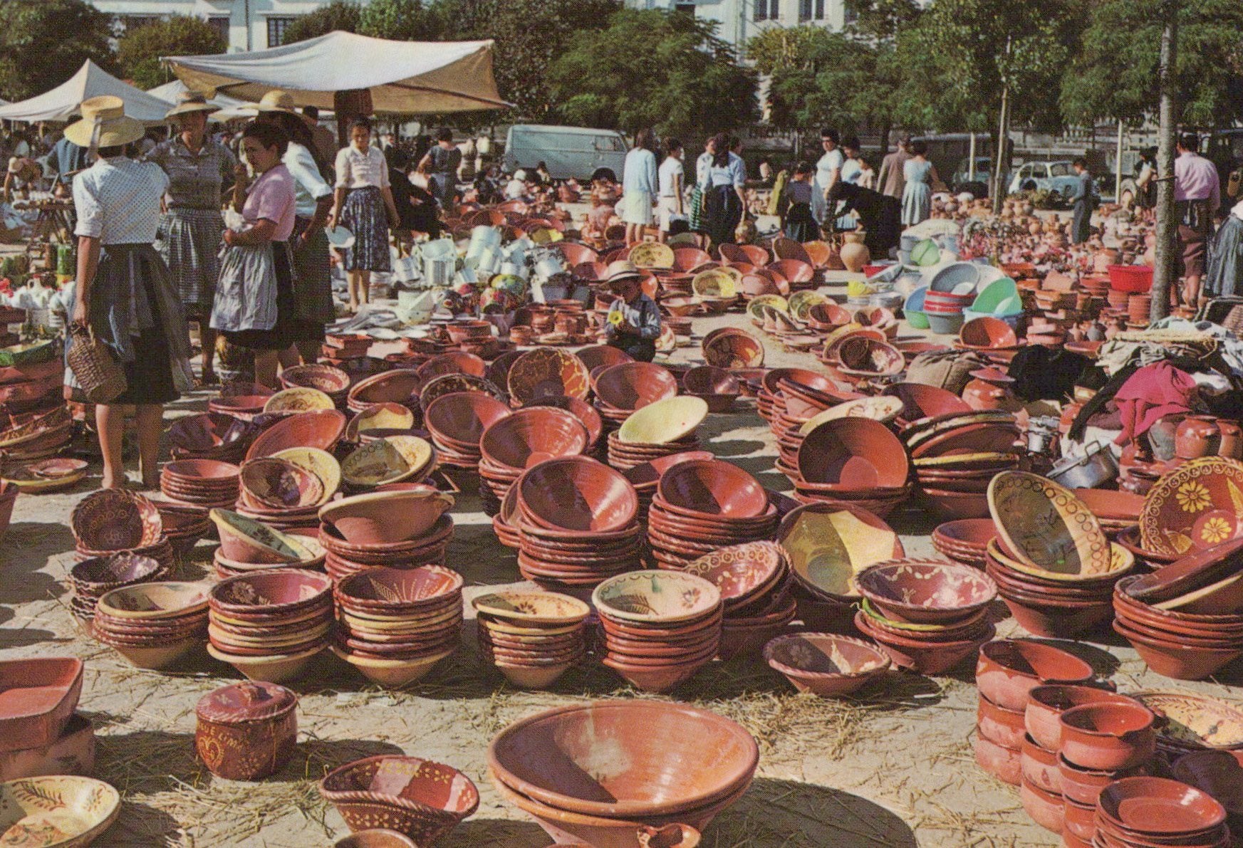 Vintage outdoor market scene with pottery and people.