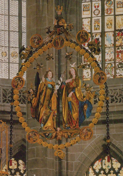 Decorative stained glass window with religious figures and intricate gold detailing in a cathedral setting.
